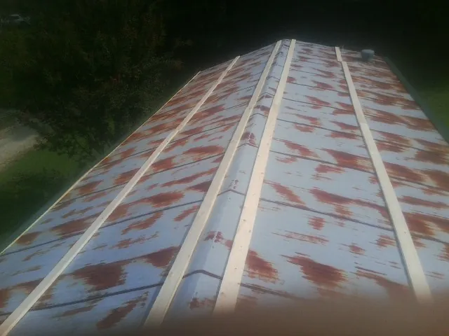 Rusted metal roof panels with new wood purlins before replacement — Storm Damage Roof Repair in Lumberton by Roofing Brothers